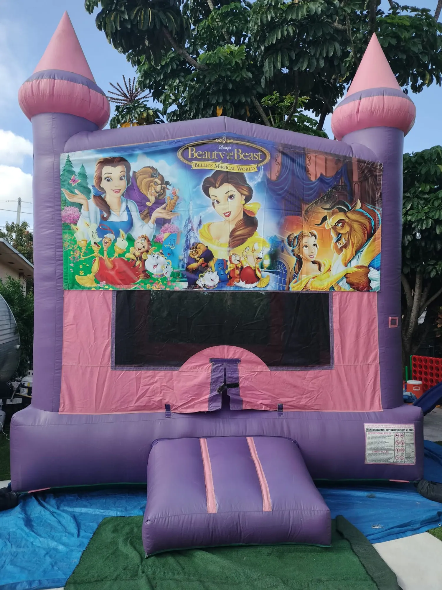 Brincolín con tema de la Bella y la Bestia montado en un patio