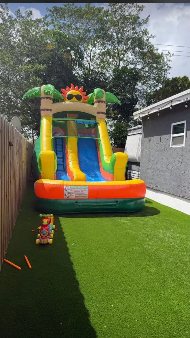 Tobogán inflable montado en el patio de una casa de Miami, sobre césped